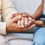 caregiver holding hands with senior