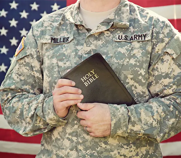 a man in military uniform holding a bible